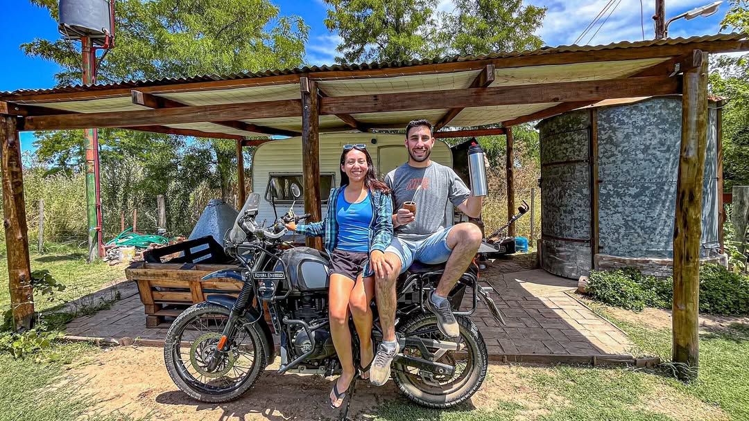 Faqundo y companera en moto Royal Enfield tomando mate
